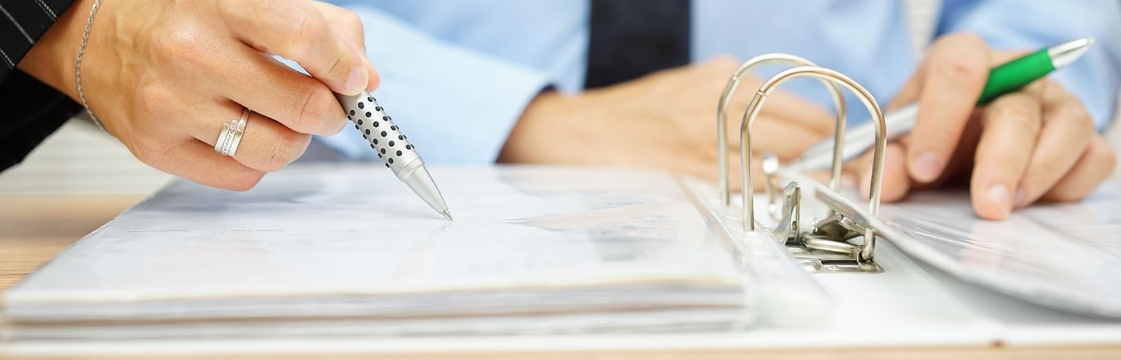 Person mit Kugelschreiber in der Hand schreibt mit einem Kugelschreiber in den Ordner Person mit Kugelschreiber in der Hand schreibt mit einem Kugelschreiber in den Ordner